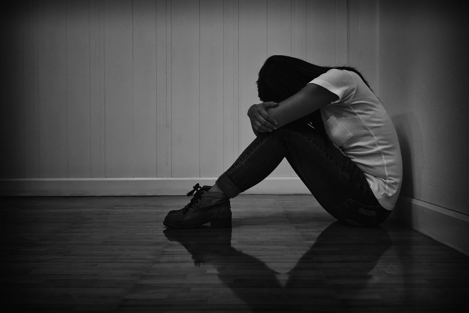 A woman sitting alone in a darkened room